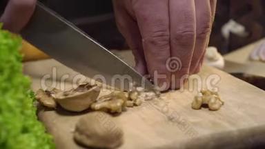 特写视频：厨师在木板上切核桃，烹饪沙拉，维生素素食，切坚果